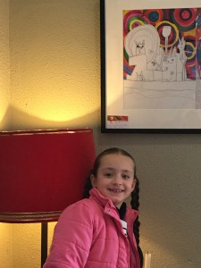 Naomi - young artist posing with her painting